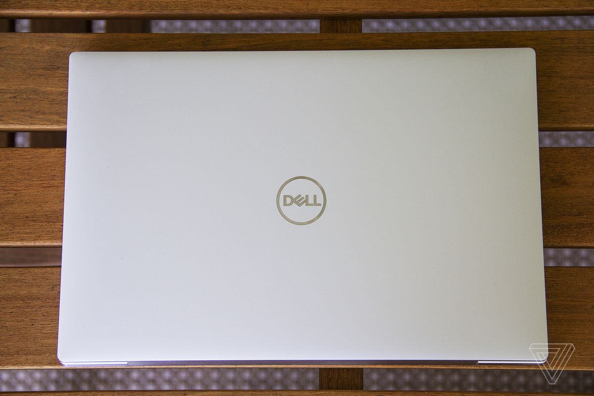 Dell XPS 13 OLED cover on a wooden table seen from above.